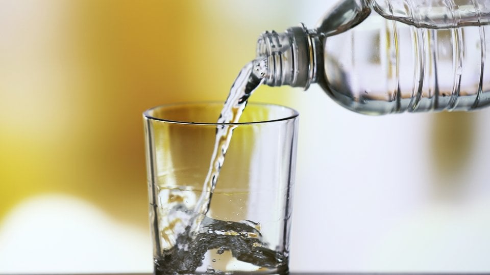 Bottled water pouring into glass