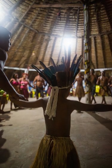 A child in traditional dress dances in circle with others
