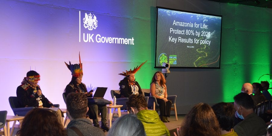 Indigenous people on stage at a conference.