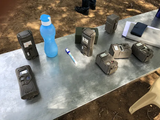A table outdoors upon which camera trapping tools are placed
