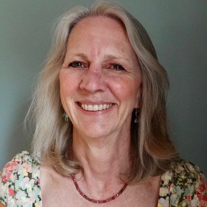 A headshot of a smiling woman