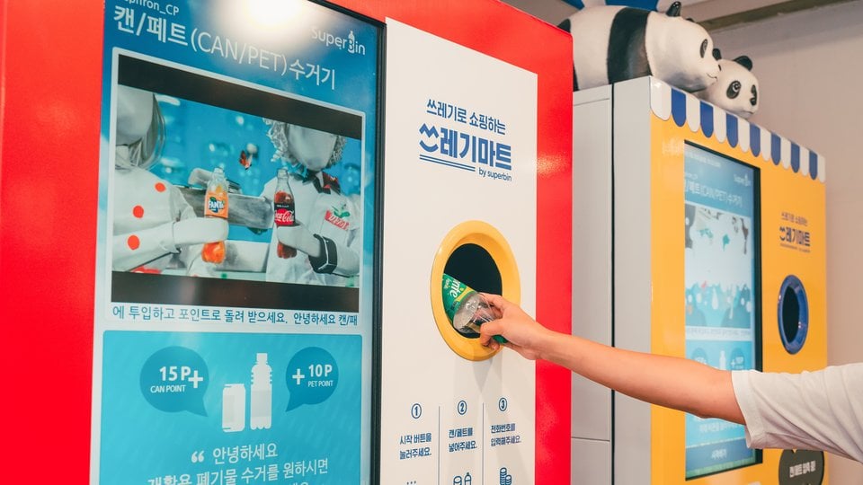 A person deposits an empty bottle into a vending machine