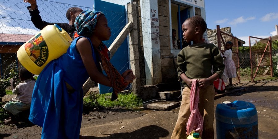 Children collect water at a kiosk in Kenya