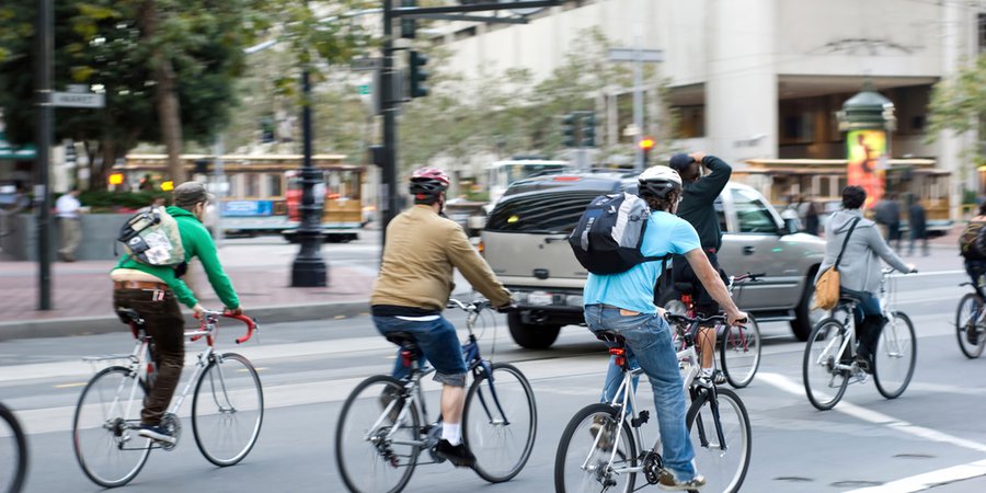 Environmentally conscious bikers cycling in traffic in San Francisco, California, United States of America.