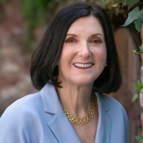 A color photo portrait of a woman in professional attire and a gold necklace