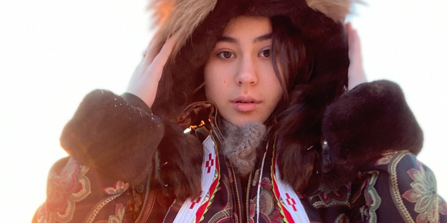 Allie Ivanoff looks straight at the camera in a large parka in the snow