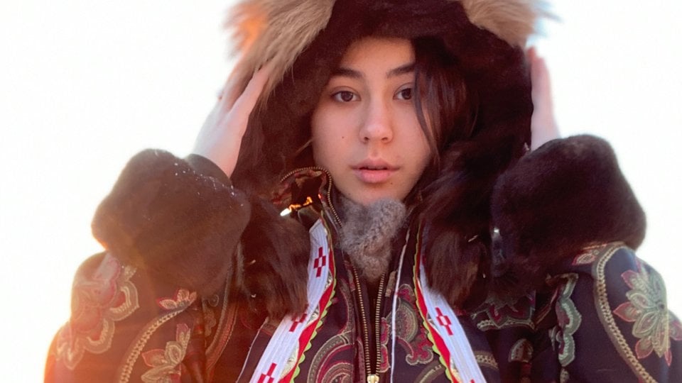 Allie Ivanoff looks straight at the camera in a large parka in the snow