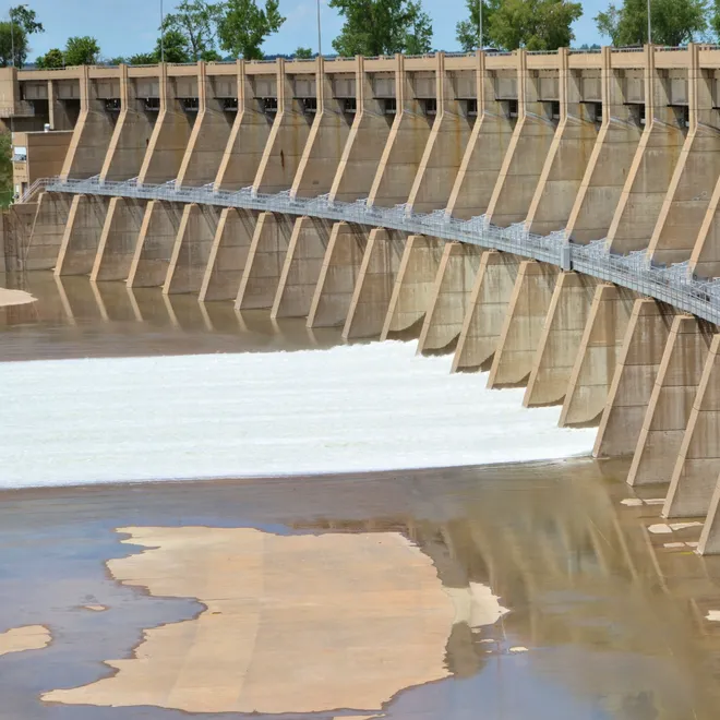 Image of a concrete dam in North Dakota. Water can be seen in the spill way.