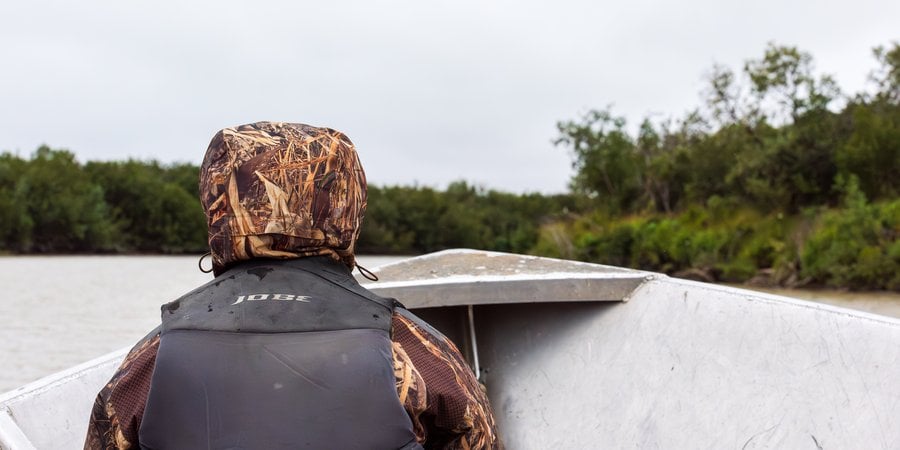 Dana Okitun, son of Marvin Okitun, looks ahead from bow of boat on Yukon River