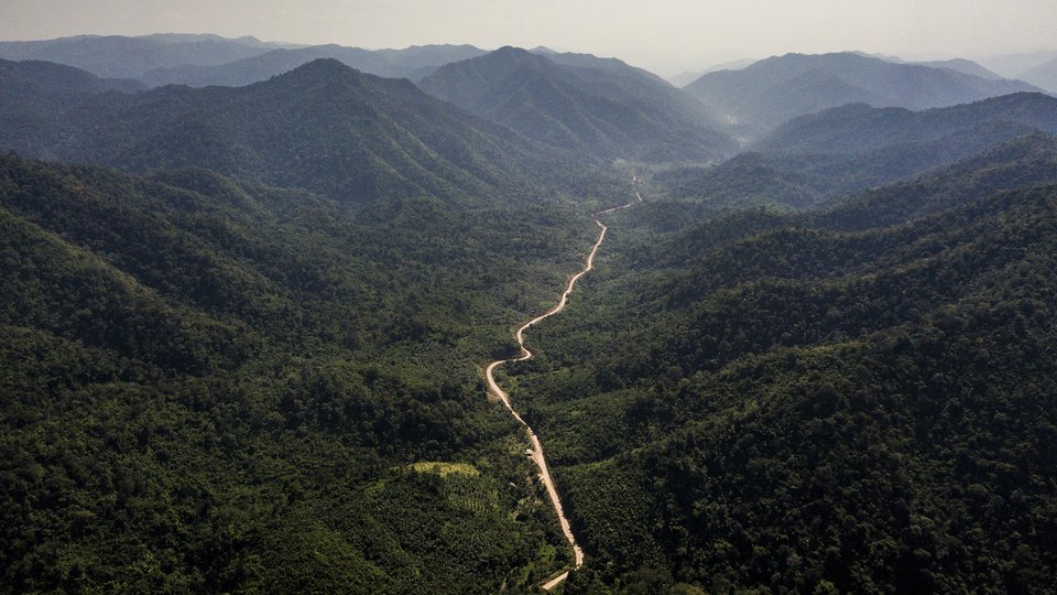 Aerial photo of Dawei Road cutting through a mountainous forest valley in Myanmar