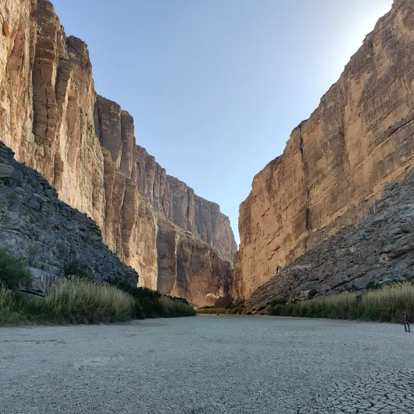 A cracked and dry riverbed is seen between a canyon