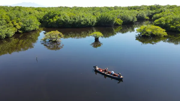A lake in an area with thick vegetation, with a fishing boat
