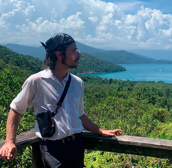 Photo of Gabriel Garcia standing on balcony overlooking the sea