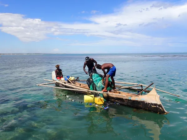 Men in a canoe with buckets and gear