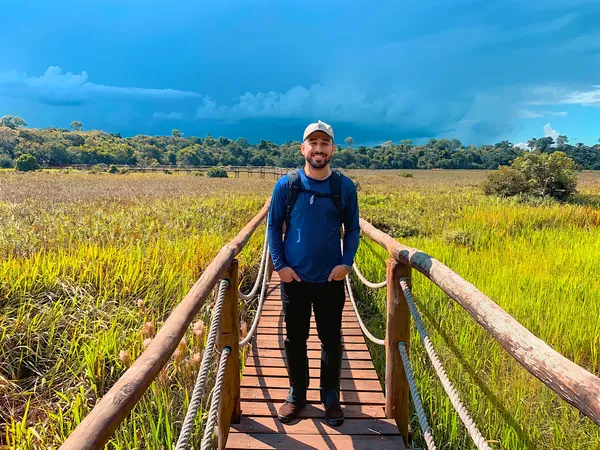 photo of Paulo Toscano standing on walking bridge over wetlands