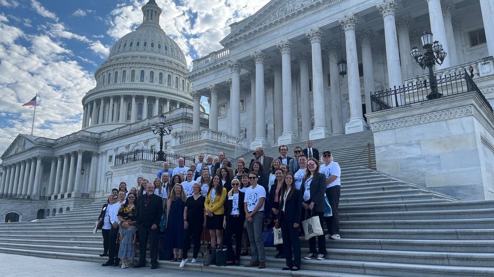 A group of activists stands on the steps of the Capitol Building in Washington DC