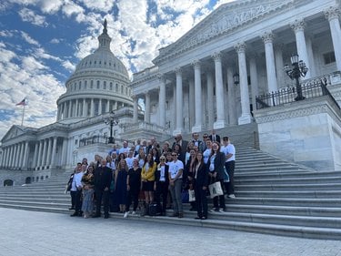 A group of activists stands on the steps of the Capitol Building in Washington DC