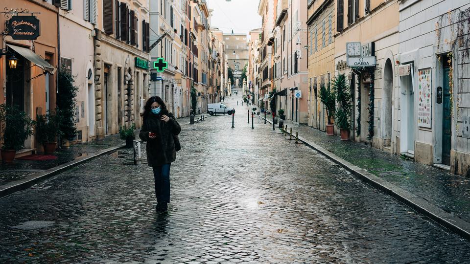 A woman walks down an empty street in a city
