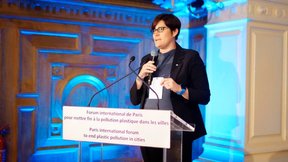 Erin Simon speaks at a podium at the Paris international forum to end plastic pollution in cities.