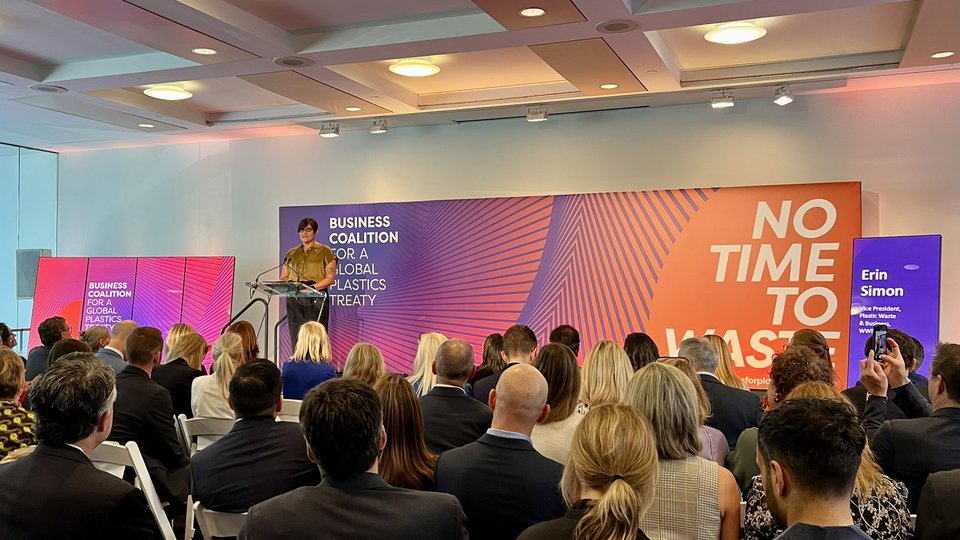 Erin Simon speaks at a podium at the Business coalition for a global plastics treaty
