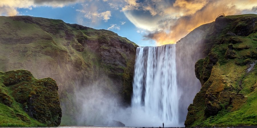 Waterfall surrounded by a rocky green landscape