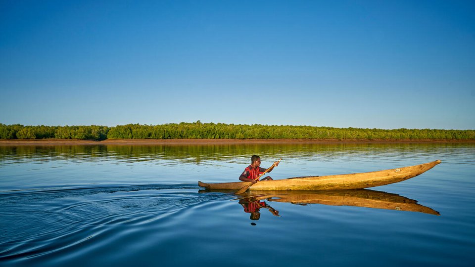 Lone fisher sets off in boat on coast of Madagascar