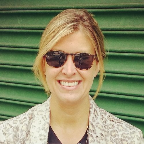 A headshot of a smiling woman with sunglasses