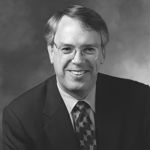 A headshot of a smiling man