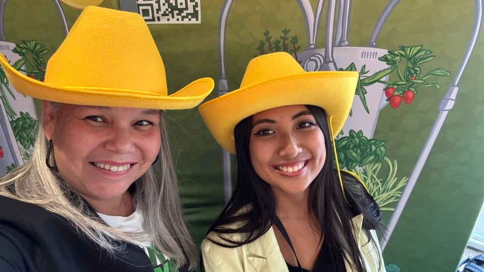 Two people pose in yellow cowboy hats