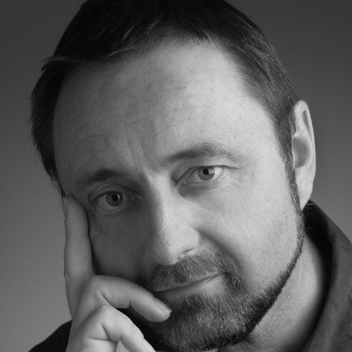 A close-up headshot of a man staring at the camera