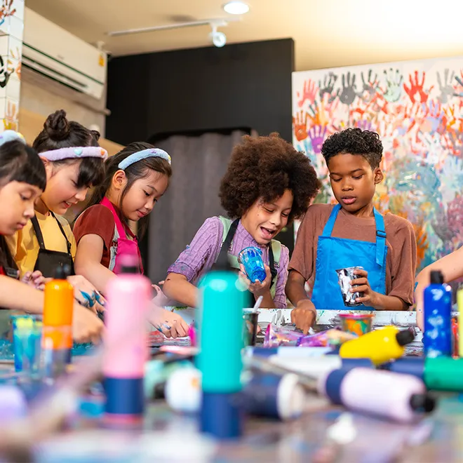 A group of kids painting on a shared surface