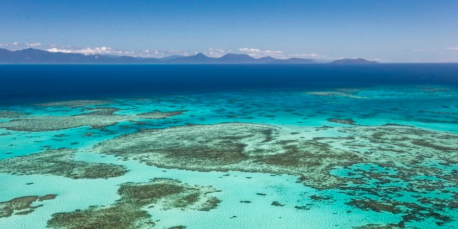 An aerial photo of shallow waters and reefs.