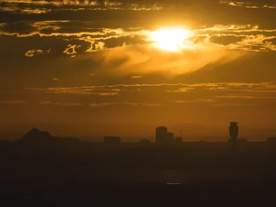 A blazing sun rises above the skyline