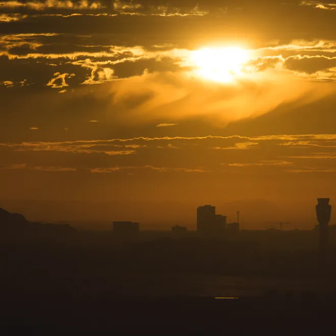 A blazing sun rises above the skyline