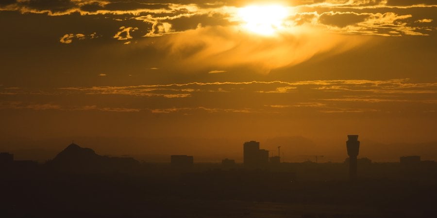 A sunset with smoggy skies over a city skyline