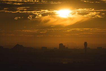 A blazing sun rises above the skyline
