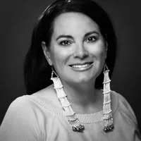 A black and white headshot of Heather Dawn. She is a Lakota attorney with long dark hair.