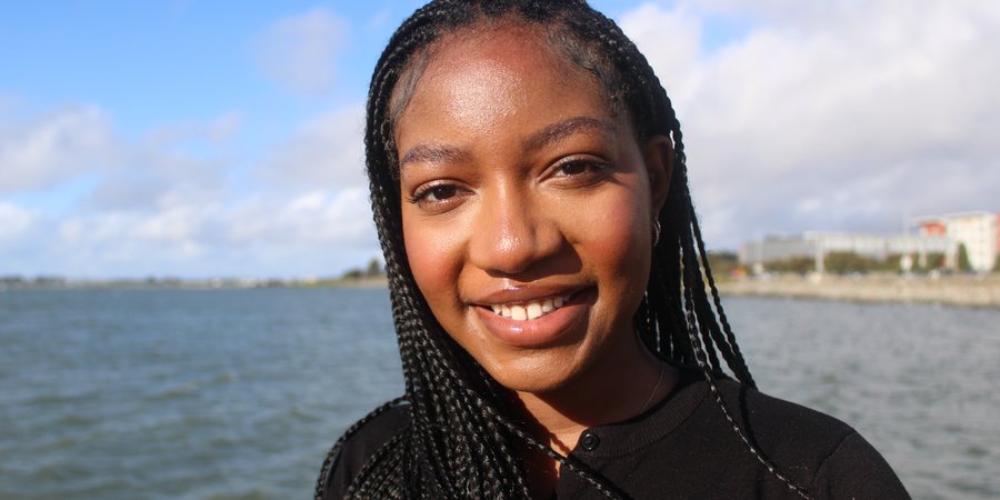 HoneyRose Smith stands on a beach and looks to the camera
