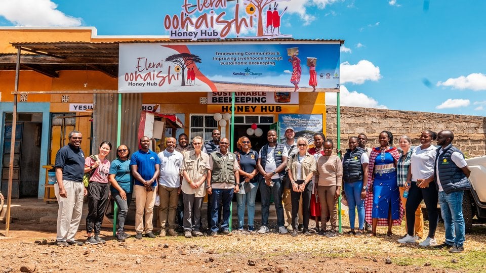 A group stands outside the Elerai Oonaishi Honey Hub storefront, Kenya