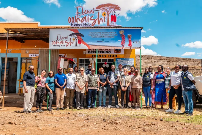A group stands outside the Elerai Oonaishi Honey Hub storefront, Kenya