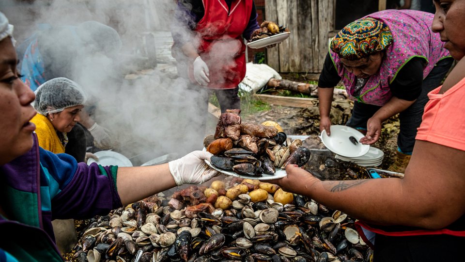 Women of Huilliche community cook curanto