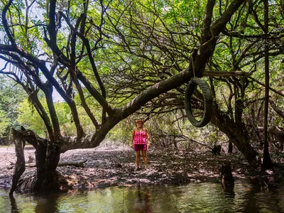Irenilse Batista Sousa stands on the shore of the river near the Kumaruara community in the Brazilian Amazon