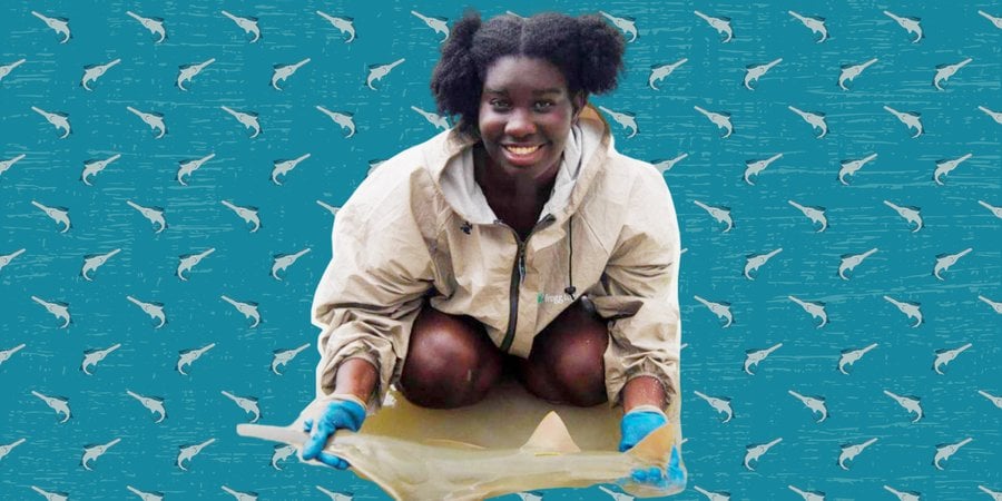 Woman crouching down holding a sawfish