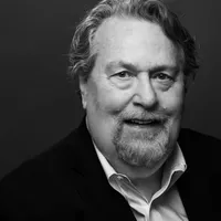 Black and white headshot of Jason smiling at the camera.