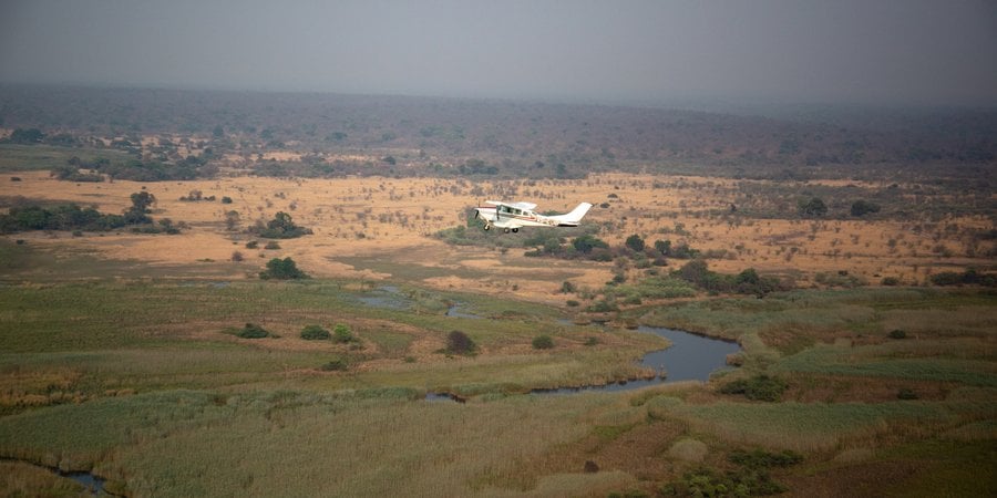 A small plane flying over the African landscape