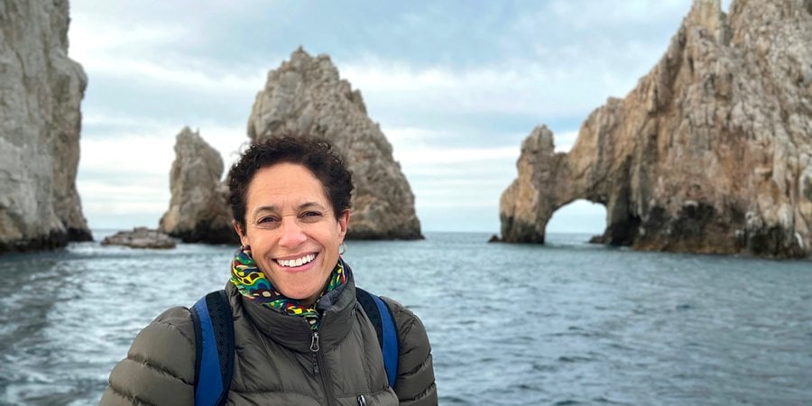Lauren Tyler standing on coast near rock formations