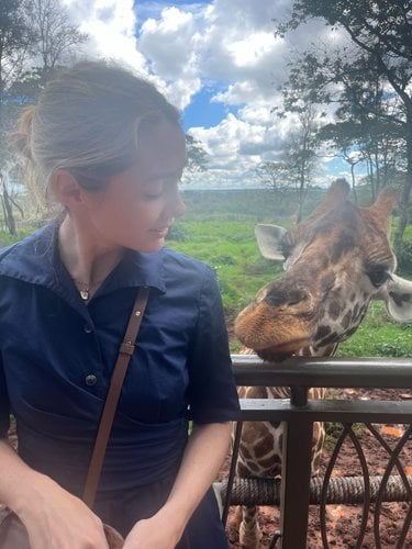 Lauren Sweeney next to a giraffe