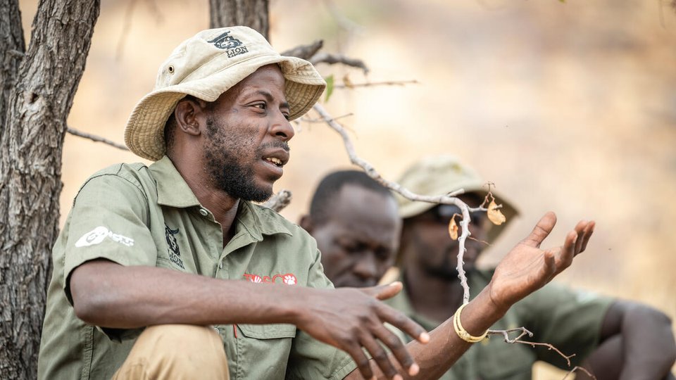 Lion Ranger Jendery Tsaneb sits under a tree and talks about human wildlife coexistence in Namibia