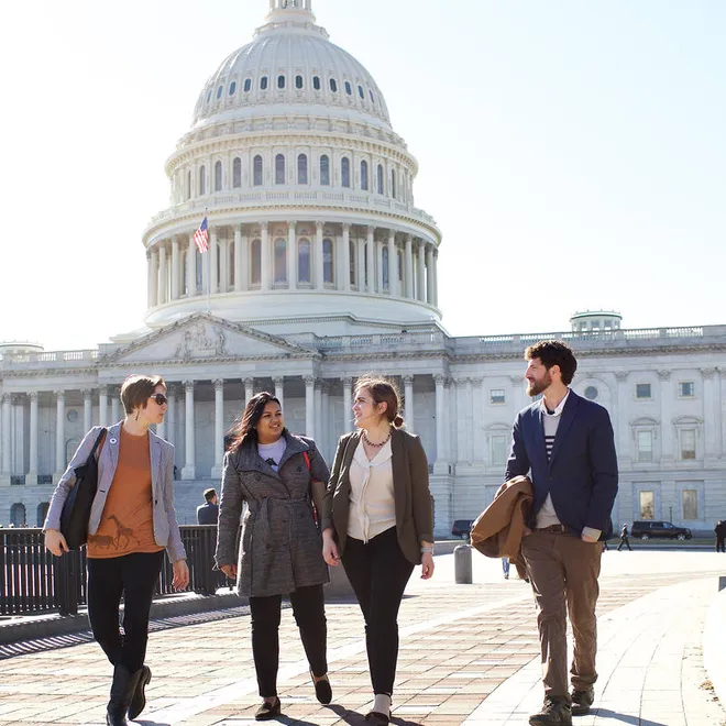 Four Lobby Day participants walk in front of the US Capitol building.