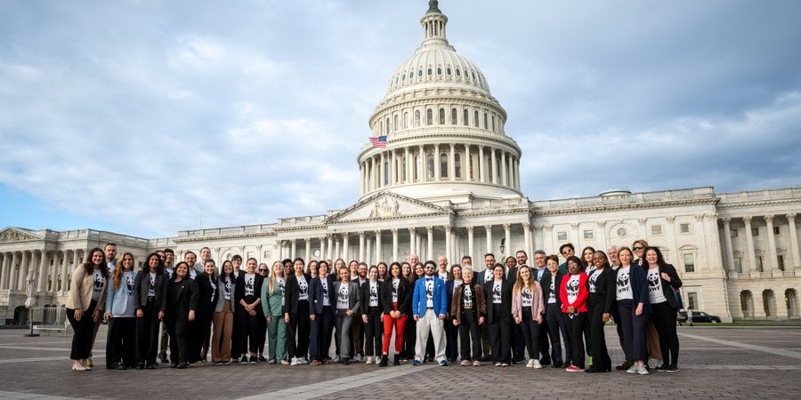 A crowd of people in WWF shirts standing outside the US Capitol building